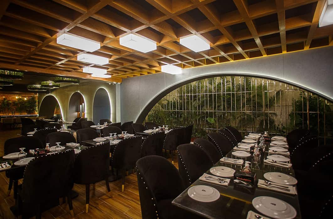 Indoor dining room with arched windows and greenery