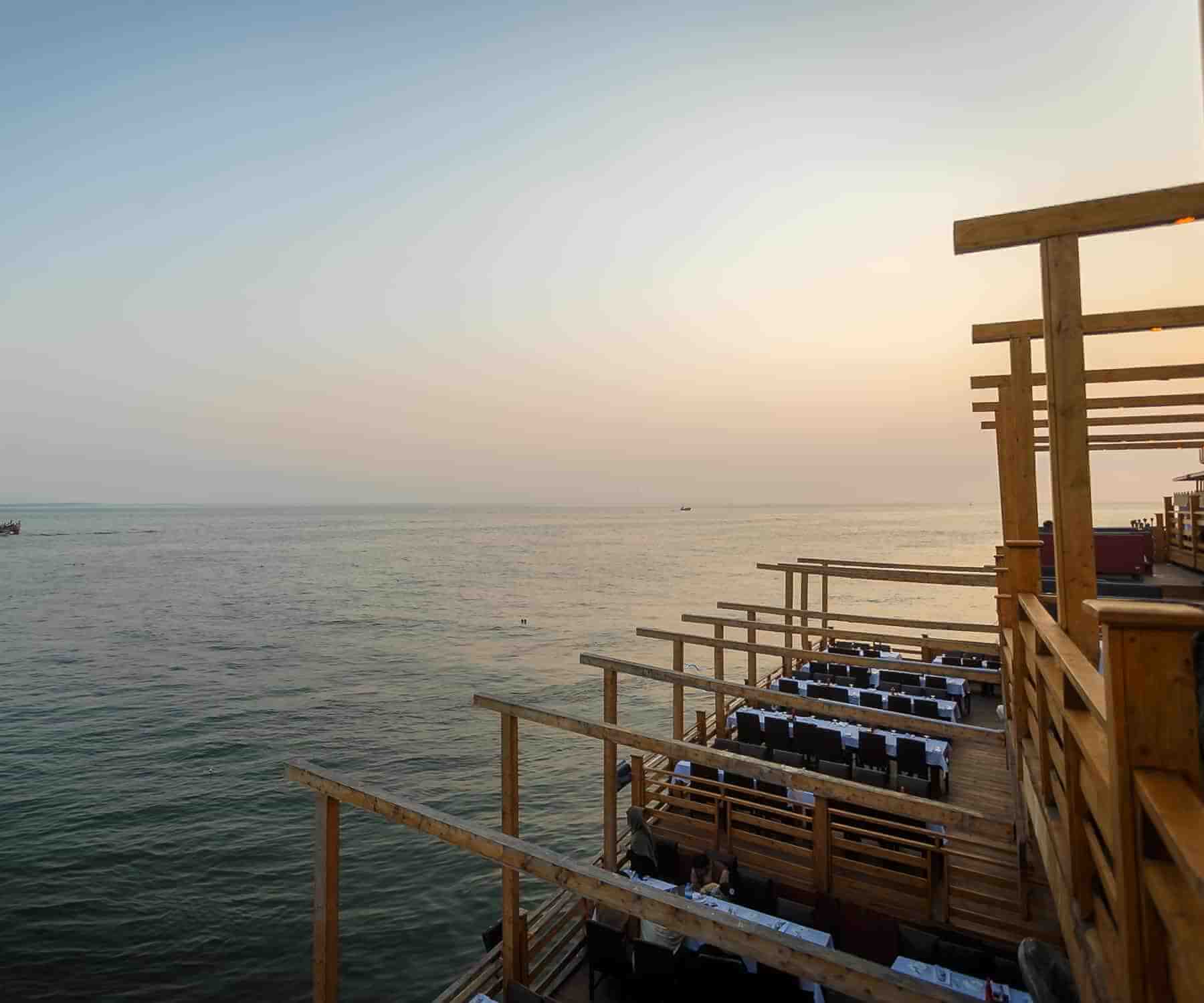 Kababjees Do Darya's wooden sea-front deck at dusk