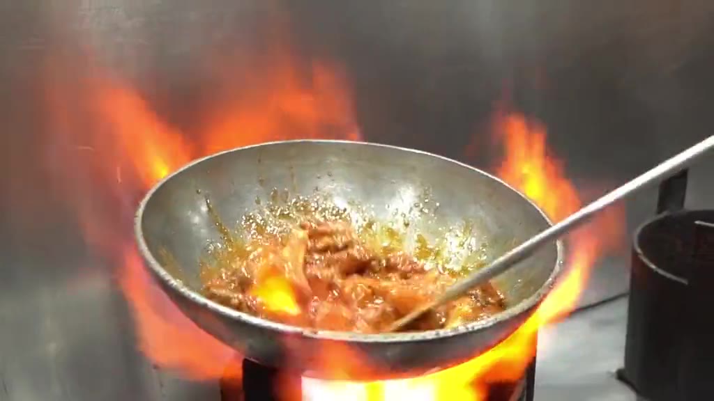 Flames leaping around a wok in the Kababjees kitchen
